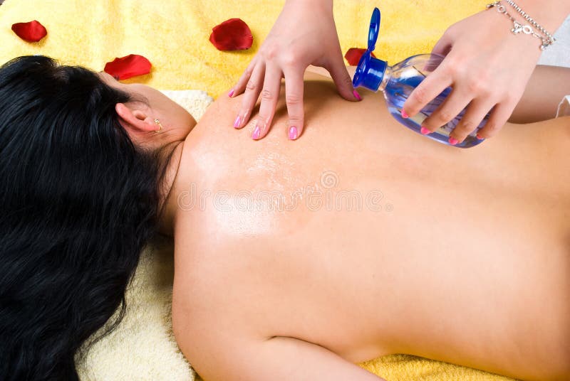 Strömende Massage ölen auf Frauenrückseite am Badekurort lizenzfreie stockfotografie Strömende Massage ölen auf Frauenrückseite am Badekurort lizenzfreie stockfotografie