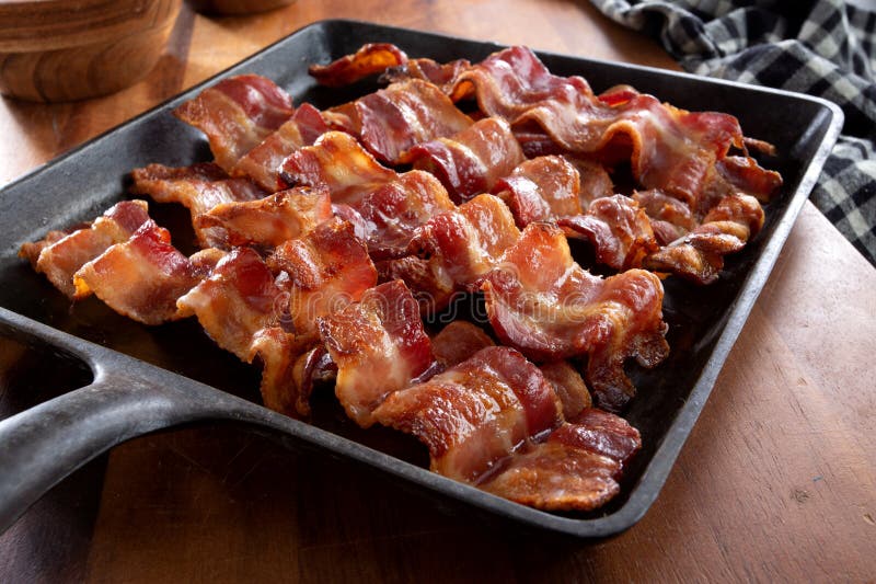 https://thumbs.dreamstime.com/b/sttrips-crispy-wavy-bacon-fried-square-cast-iron-skillet-morning-breakfast-add-to-meal-brown-wood-cutting-270215337.jpg