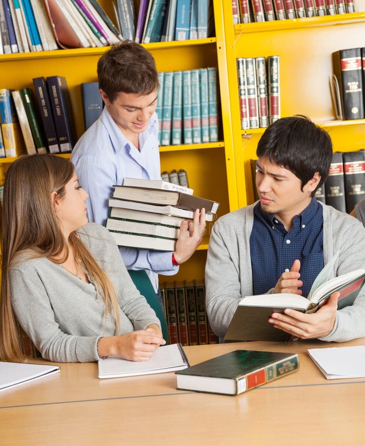 Studenckie przewożenie książki Podczas gdy przyjaciele Siedzi Wewnątrz obraz royalty free Studenckie przewożenie książki Podczas gdy przyjaciele Siedzi Wewnątrz obraz royalty free
