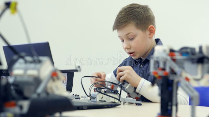 Studenckiej chłopiec gromadzić robot w robotechnics szkoły sala lekcyjnej Inżynier edukaci pojęcie zdjęcie wideo