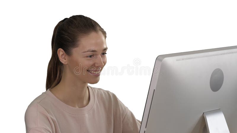 Student blonde girl die de monitor van de computer bekijkt en glimlacht op witte achtergrond