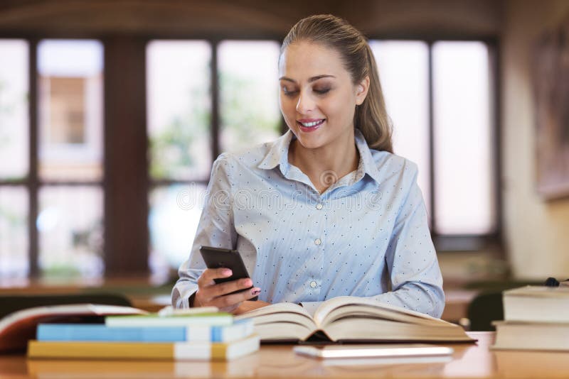 Student, der an der Bibliothek simst stockbilder Student, der an der Bibliothek simst stockbilder