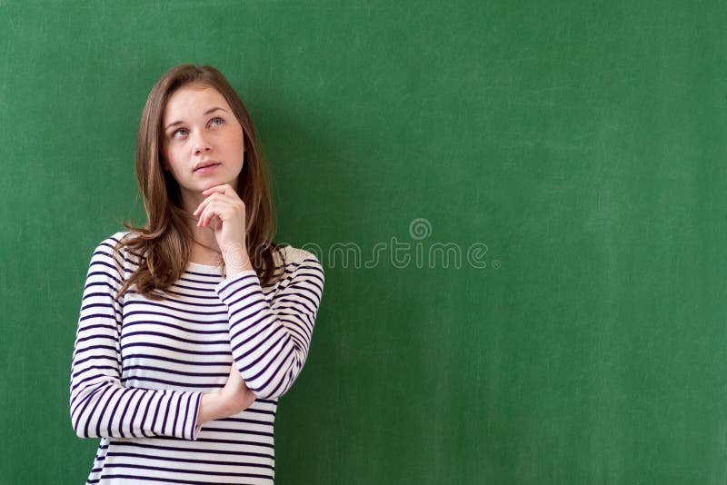 Student die en tegen groene bordachtergrond denken leunen Peinzend meisje dat omhoog kijkt Kaukasisch vrouwelijk studentenportret stock foto Student die en tegen groene bordachtergrond denken leunen Peinzend meisje dat omhoog kijkt Kaukasisch vrouwelijk studentenportret stock foto