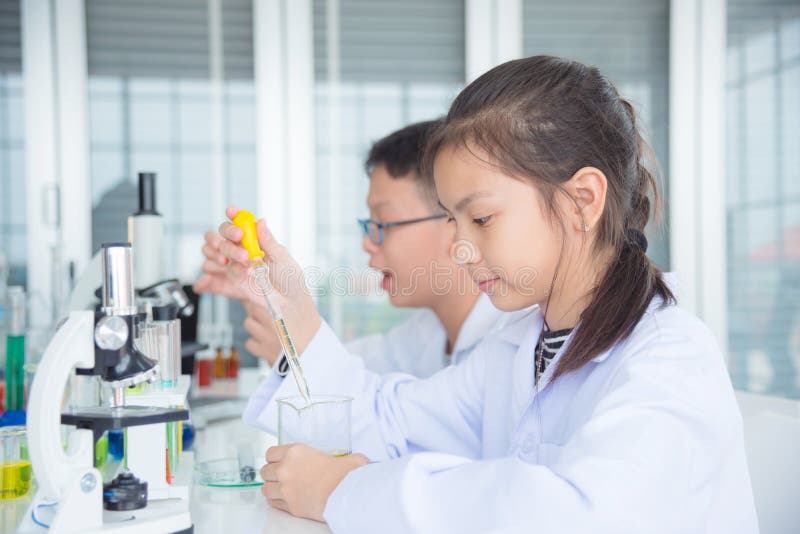 Student die experiment in chemieklaslokaal doen stock afbeeldingen Student die experiment in chemieklaslokaal doen stock afbeeldingen