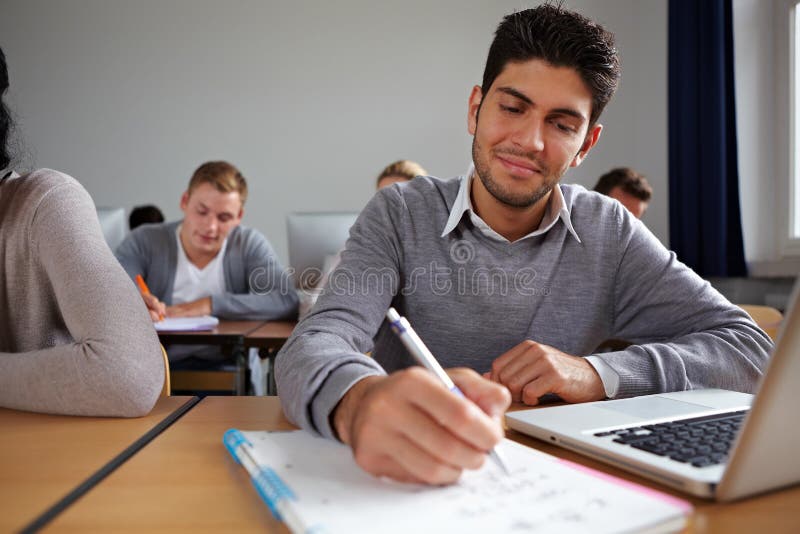 Student with computer taking notes in university class. Student with computer taking notes in university class