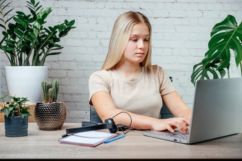 Student girl in headphones watching online video zoom class webinar in virtural classroom on her laptop royalty free stock photos