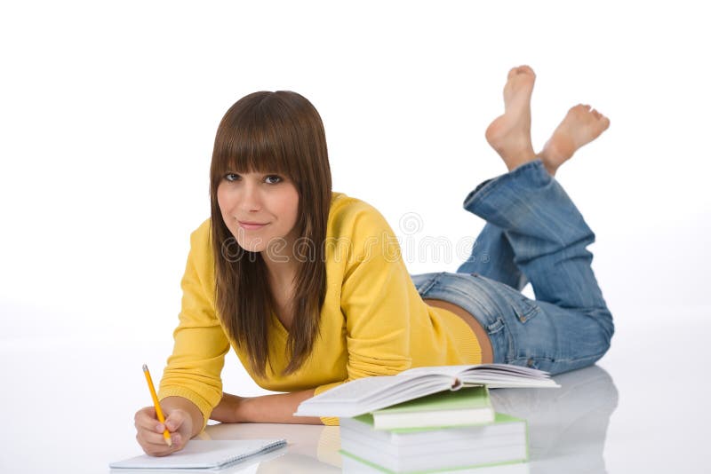Student - Happy female teenager write homework royalty free stock photos