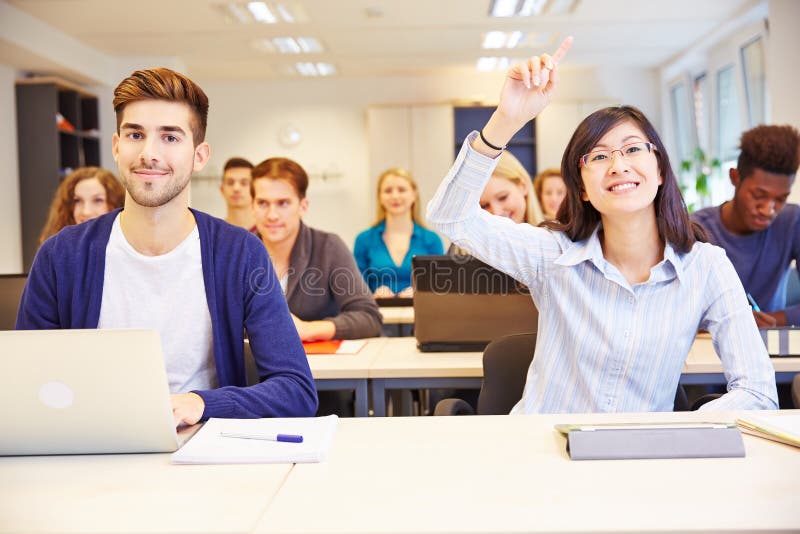 Asian student raising her hand in a university classroom. Asian student raising her hand in a university classroom