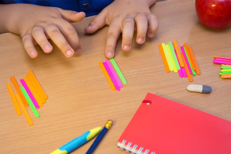The student& x27;s hands are counted as multi-colored sticks close-up. royalty free stock photo
