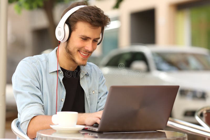 Student som lär med en bärbar dator i en stång arkivbild Student som lär med en bärbar dator i en stång arkivbild