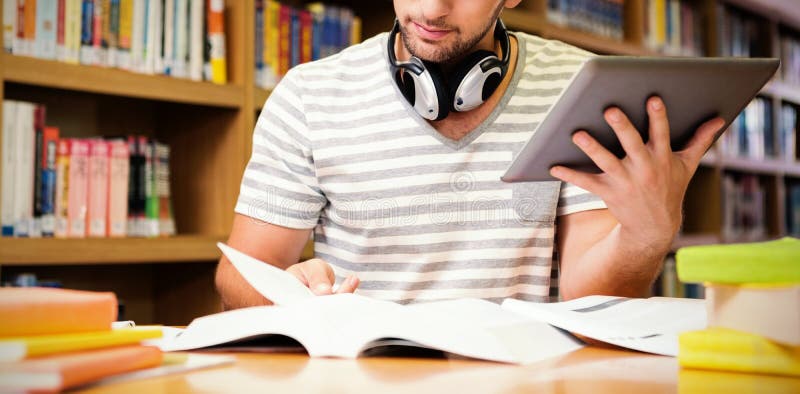 Student studying in library with tablet at university. Student studying in library with tablet at university