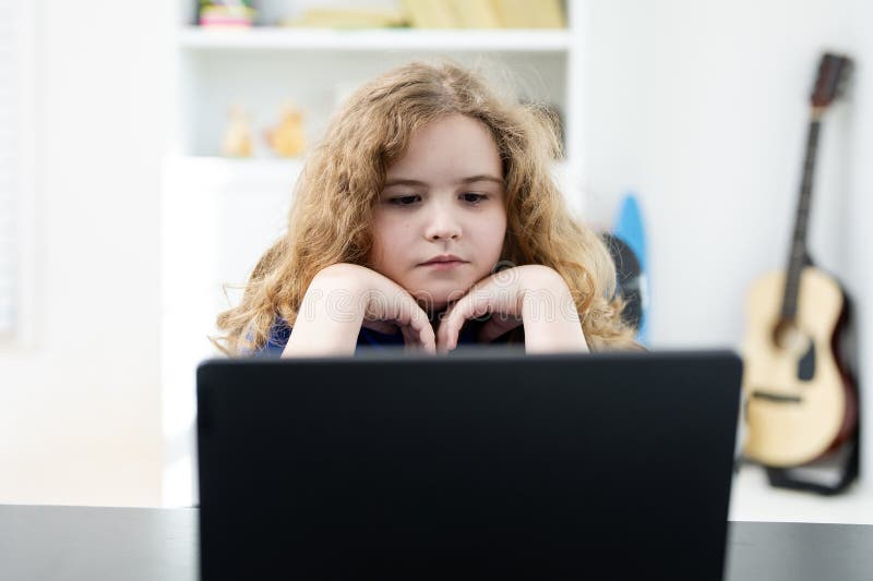 Student thinking during lesson. Kid learning at home school. Child typing on laptop. Boy focused on digital schoolwork. Child stock photography