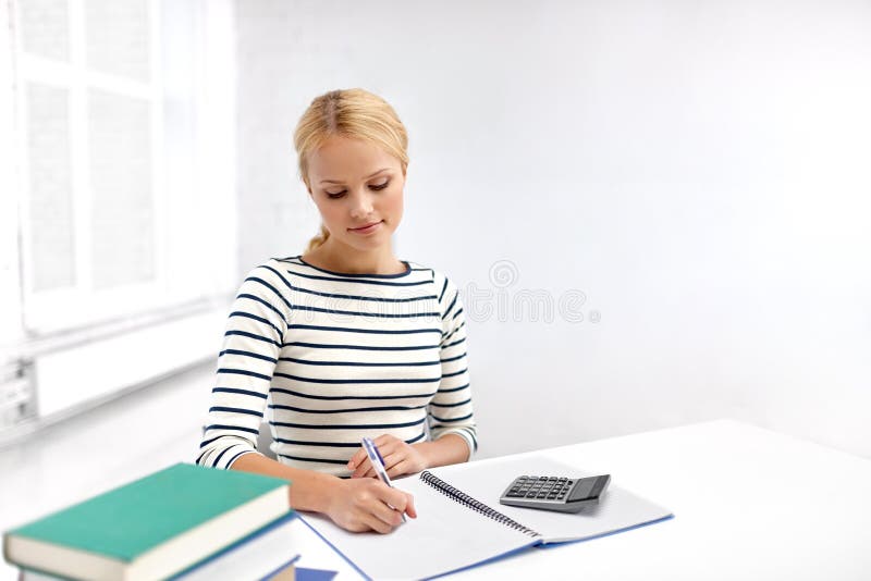 Student woman with books writing to notebook royalty free stock image