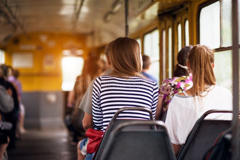 Student women taking a ride in public transport from the work at sunset time stock image