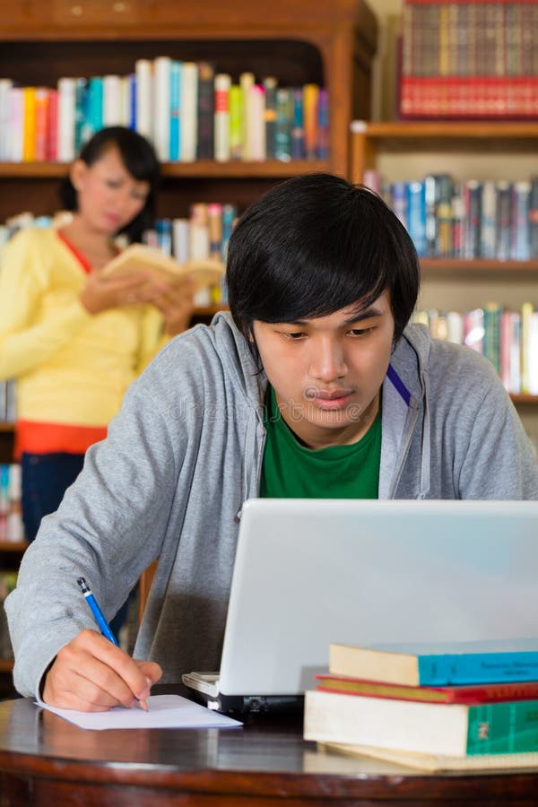 Man in library with laptop stock images Man in library with laptop stock images