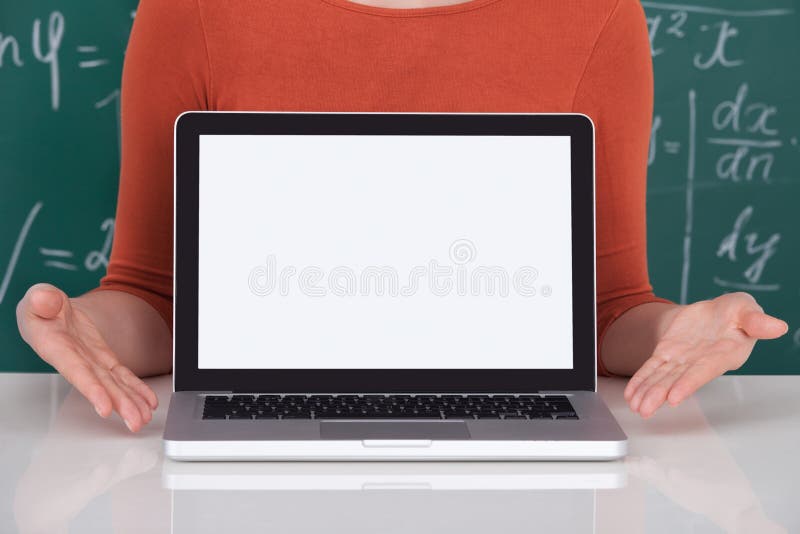 Studente che visualizza computer portatile con lo schermo in bianco in aula fotografia stock