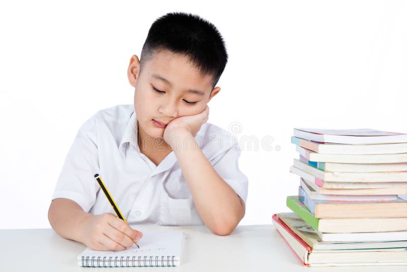 Studente d'uso Uniform Writting di Little Boy di cinese asiatico annoiato