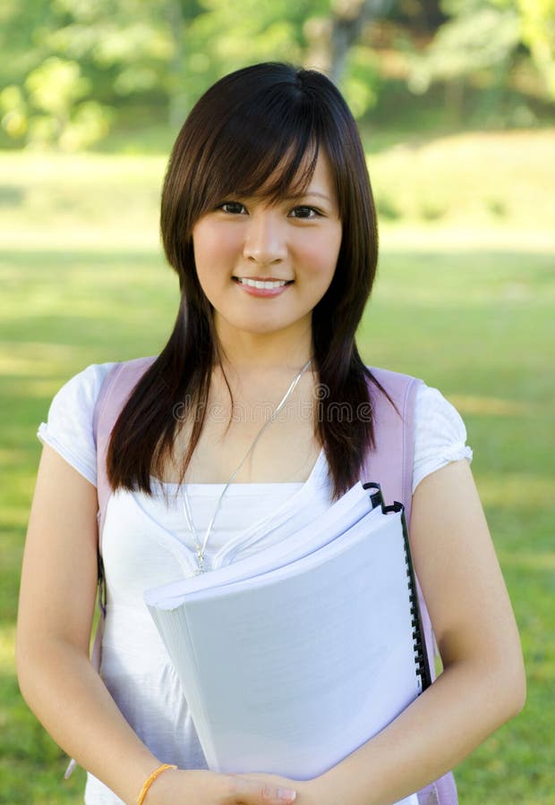 College student standing outside campus, green park. College student standing outside campus, green park