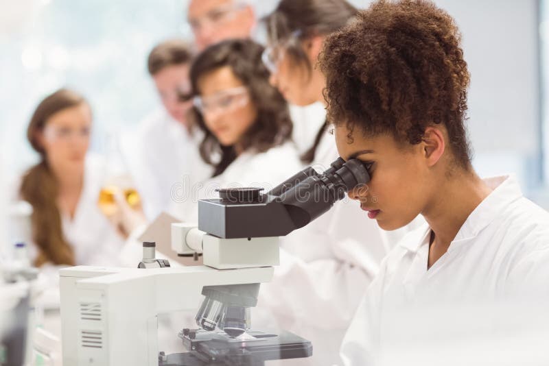Studente di scienza che guarda tramite il microscopio in laboratorio