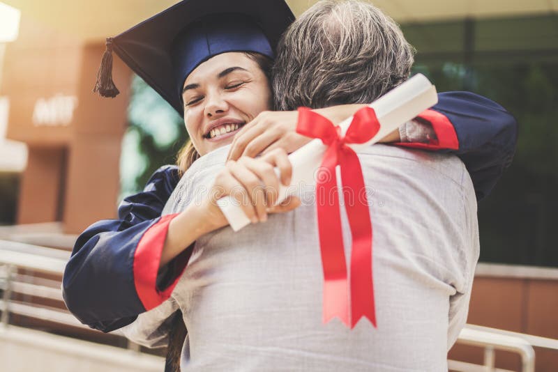 Studente graduato che abbraccia suo padre immagini stock libere da diritti Studente graduato che abbraccia suo padre immagini stock libere da diritti
