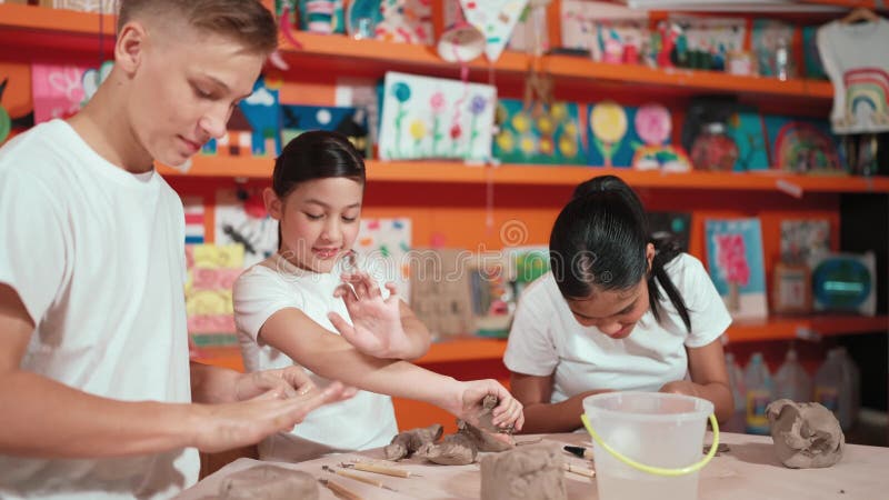 Studente intelligente che usa la mano sul pezzo di argilla al laboratorio di ceramica. costruzione