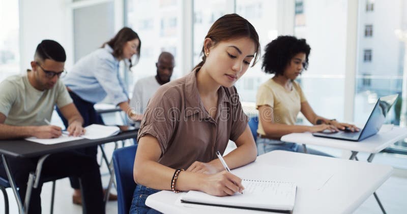 Studentek kobiet i pisanie ze sprawdzianem w klasie na studia lub pracę na uniwersytecie. kobieta lub grupa zdjęcie royalty free