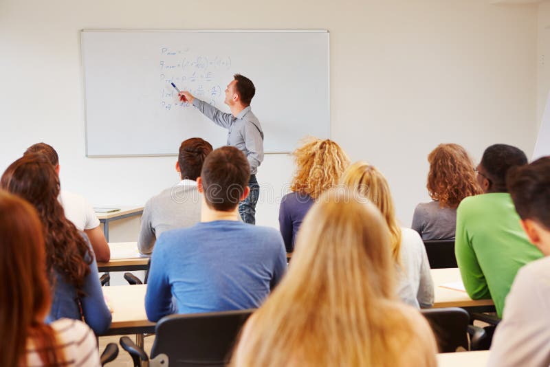 Students listening to teacher in class on a whiteboard. Students listening to teacher in class on a whiteboard