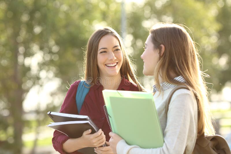 Studenten, die in einem Campus gehen und sprechen lizenzfreies stockbild Studenten, die in einem Campus gehen und sprechen lizenzfreies stockbild