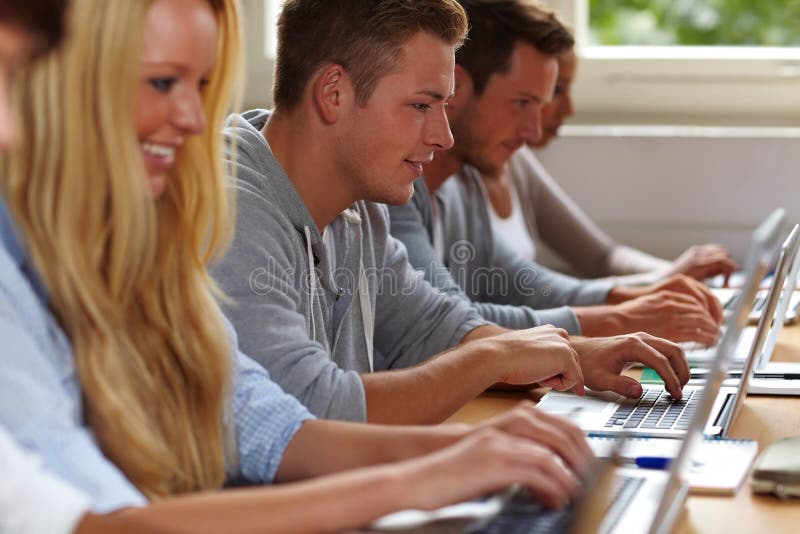 Happy students using their laptops in university class. Happy students using their laptops in university class