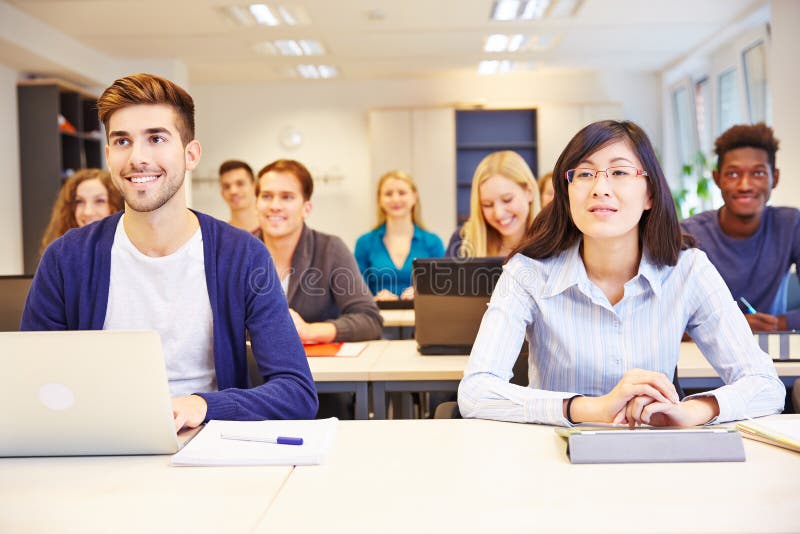 Many smiling students learning in a university class. Many smiling students learning in a university class