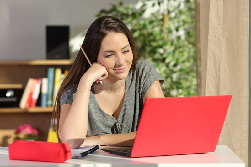 Studentene-learning zu Hause unter Verwendung eines Laptops lizenzfreies stockfoto Studentene-learning zu Hause unter Verwendung eines Laptops lizenzfreies stockfoto
