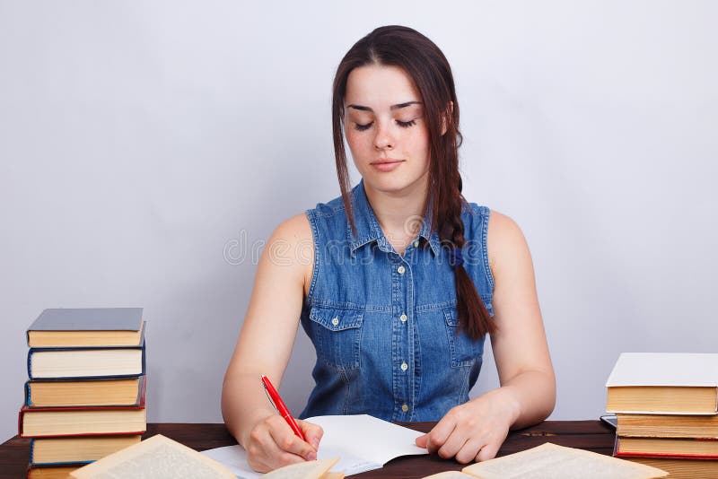Studentenmeisje die, handboek lezen en materiaal opmerken aan bestuderen stock afbeelding Studentenmeisje die, handboek lezen en materiaal opmerken aan bestuderen stock afbeelding