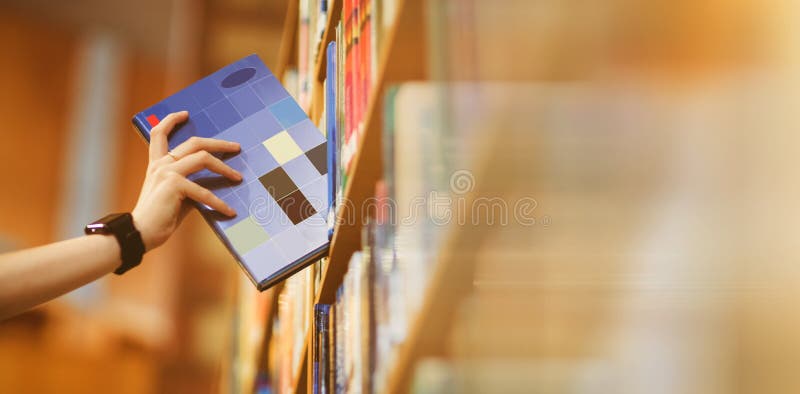 Students hand with smartwatch picking book from bookshelf at university. Students hand with smartwatch picking book from bookshelf at university