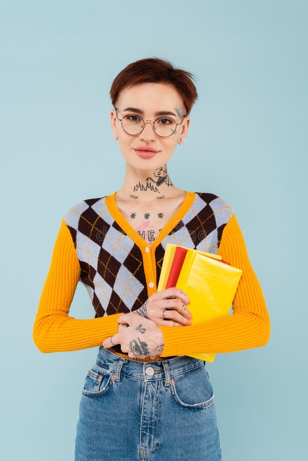 Studentessa allegra tatuata con gli occhiali in mano fotografia stock