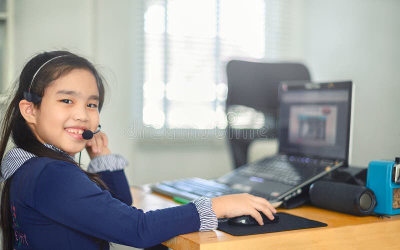 Studentessa asiatica indossa cuffie orologio webinar ascoltare corso online comunicare con una videoconferenza . l'alloggio e