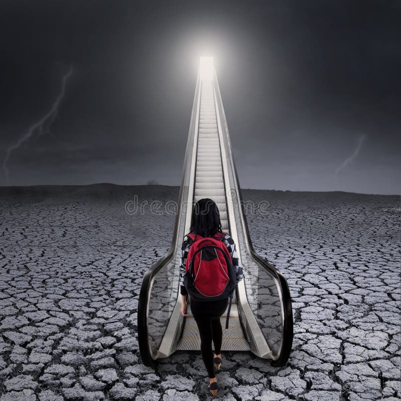 Una studentessa sale sulla scala mobile fotografia stock libera da diritti