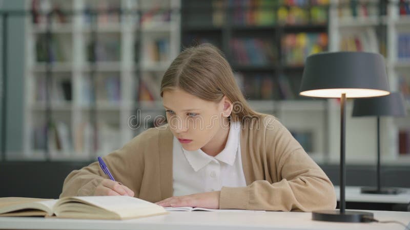 Studentessa che scrive nel libro degli esercizi in classe