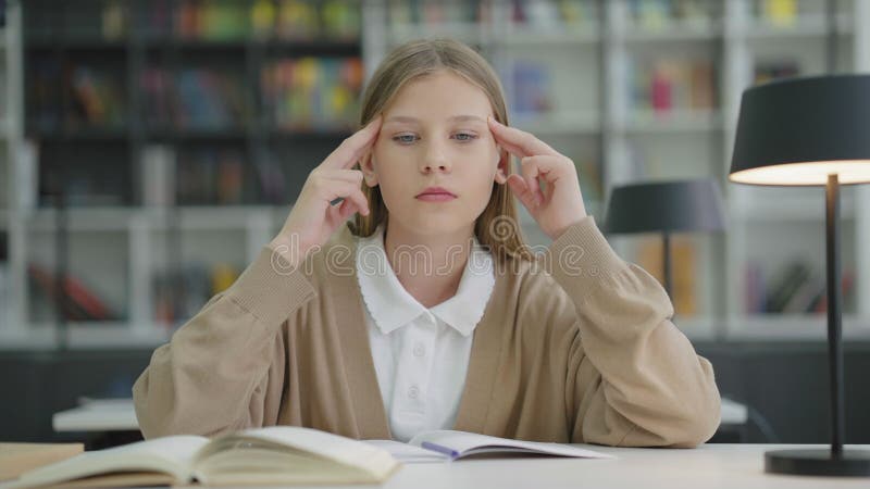 Studentessa con mal di testa che massaggia la testa in classe