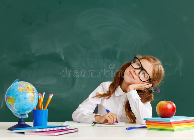 Studentessa della scolara del bambino circa la lavagna della scuola fotografia stock Studentessa della scolara del bambino circa la lavagna della scuola fotografia stock