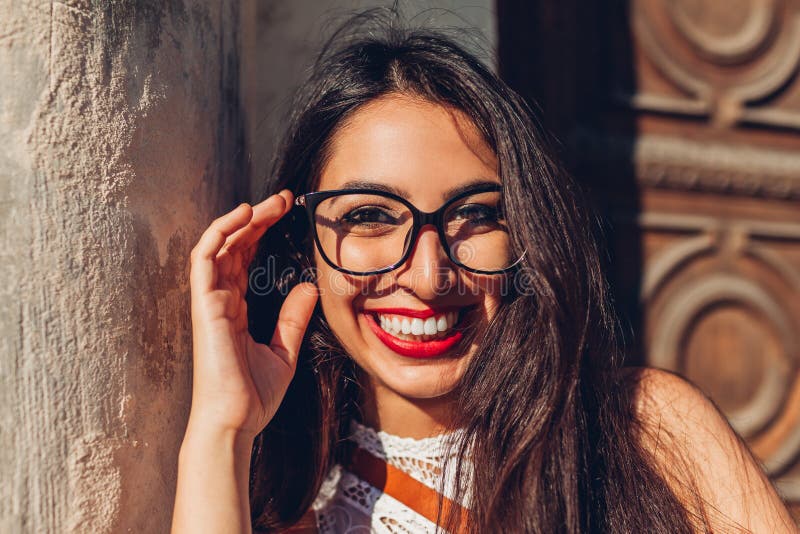 Studentessa di college del Medio-Oriente felice che sorride e che esamina macchina fotografica Ritratto all'aperto dei vetri d'us immagine stock Studentessa di college del Medio-Oriente felice che sorride e che esamina macchina fotografica Ritratto all'aperto dei vetri d'us immagine stock