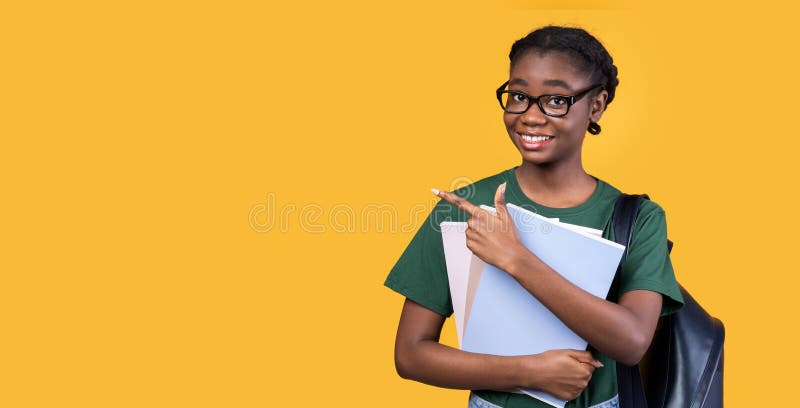 Studentessa nera che punta il dito contro lo sfondo giallo fotografia stock libera da diritti