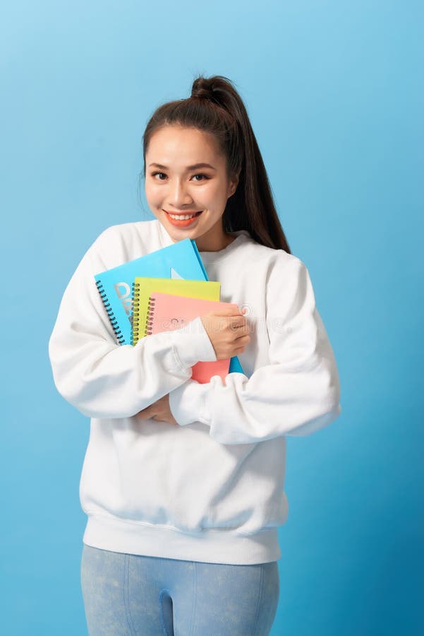 Studentessa piacevole che sorride e che esamina macchina fotografica fotografie stock libere da diritti Studentessa piacevole che sorride e che esamina macchina fotografica fotografie stock libere da diritti