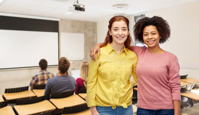 Studentesse felici che sorridono abbracciate all'università fotografie stock libere da diritti