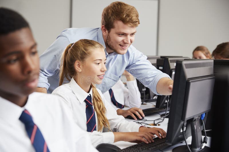Studenti adolescenti che portano uniforme che studia nella classe dell'IT immagine stock libera da diritti Studenti adolescenti che portano uniforme che studia nella classe dell'IT immagine stock libera da diritti