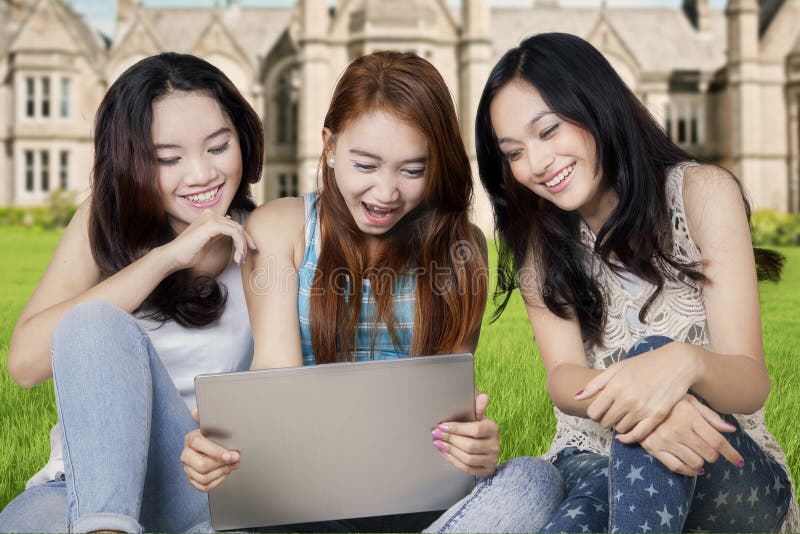Studenti adolescenti con il computer portatile al cortile della scuola fotografia stock libera da diritti Studenti adolescenti con il computer portatile al cortile della scuola fotografia stock libera da diritti