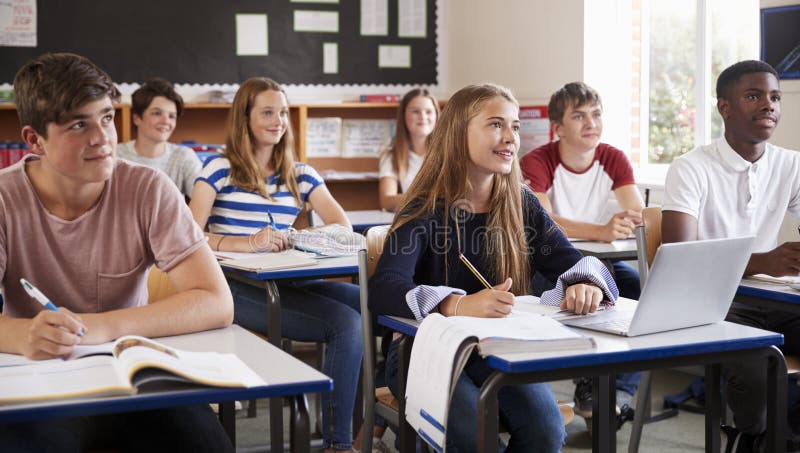 Studenti che ascoltano l'insegnante femminile In Classroom fotografia stock libera da diritti Studenti che ascoltano l'insegnante femminile In Classroom fotografia stock libera da diritti