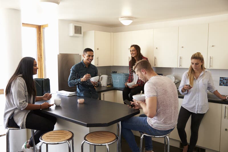 Students Relaxing In Kitchen Of Shared Accommodation. Students Relaxing In Kitchen Of Shared Accommodation