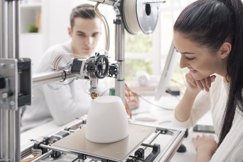 Studenti di ingegneria che utilizzano una stampante 3D nel laboratorio fotografie stock libere da diritti Studenti di ingegneria che utilizzano una stampante 3D nel laboratorio fotografie stock libere da diritti