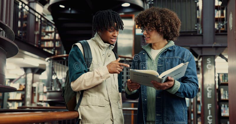 Studenti e libri per l'istruzione in biblioteca studiando informazioni e preparandosi agli esami. Persone, amici e fotografie stock