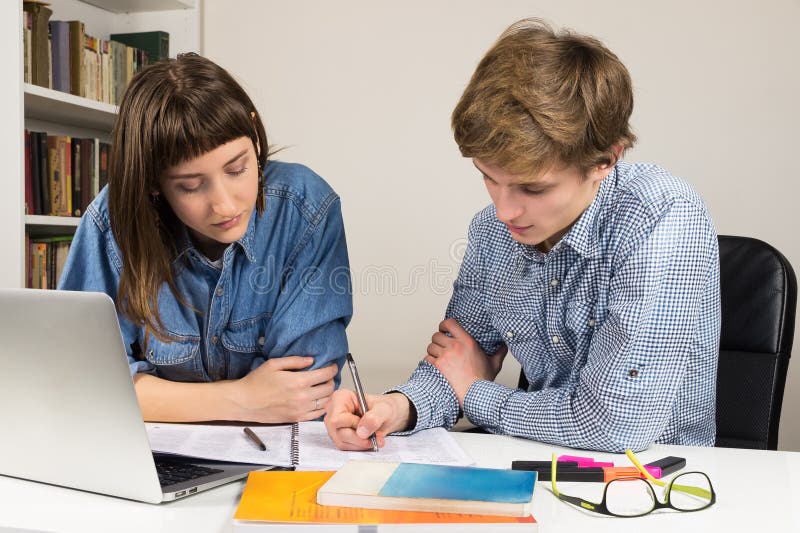 Studenti femminili e maschii chelavorano su un'assegnazione del lavoro o della scuola immagine stock libera da diritti Studenti femminili e maschii chelavorano su un'assegnazione del lavoro o della scuola immagine stock libera da diritti